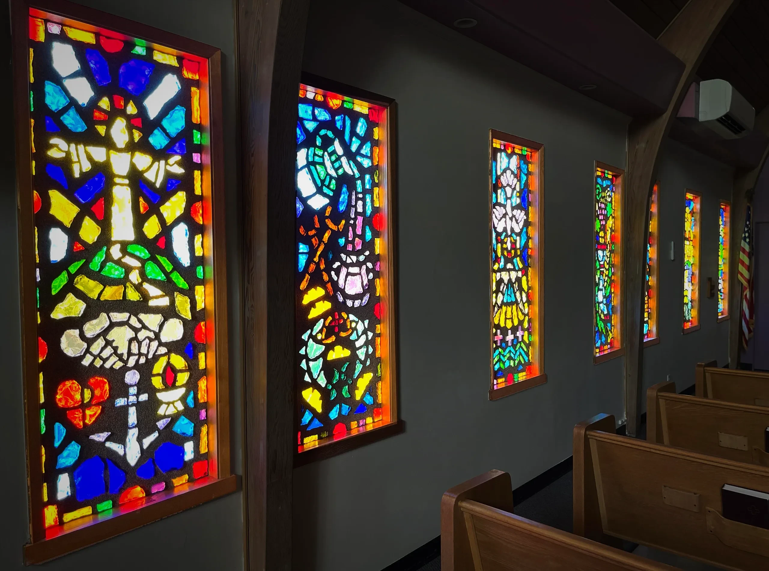 Colorful stained glass windows lining the nave of St. John's Lutheran Church
