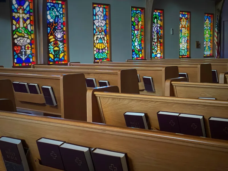 Church pews with colorful stained glass windows