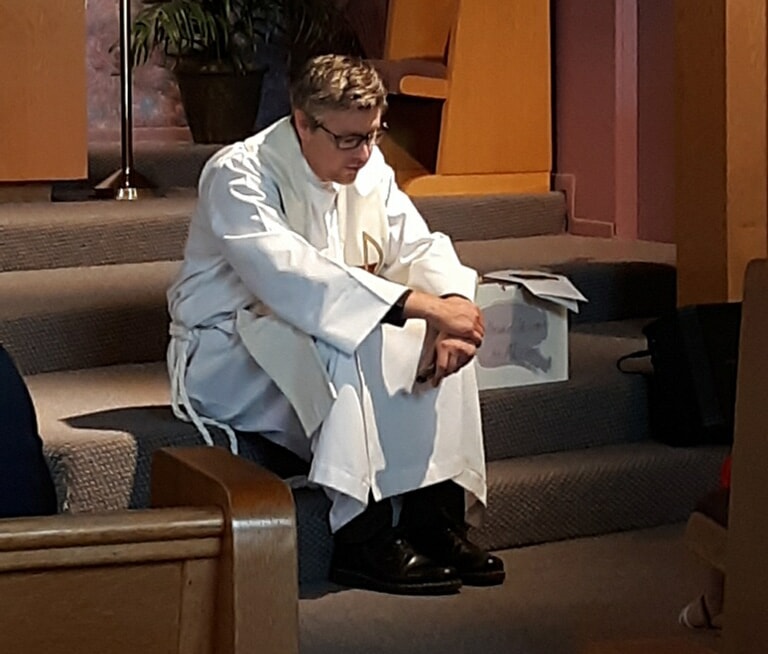 Pastor Scott seated on the altar steps